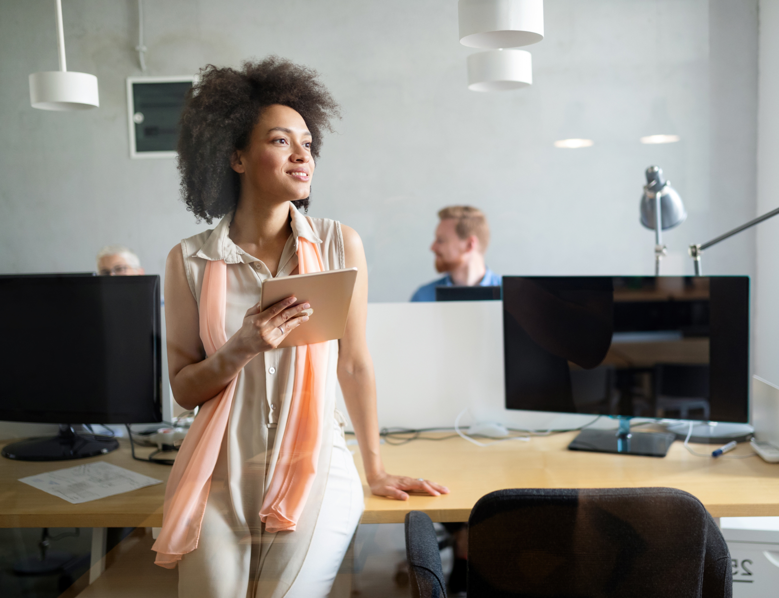 Woman sitting on desk in an office