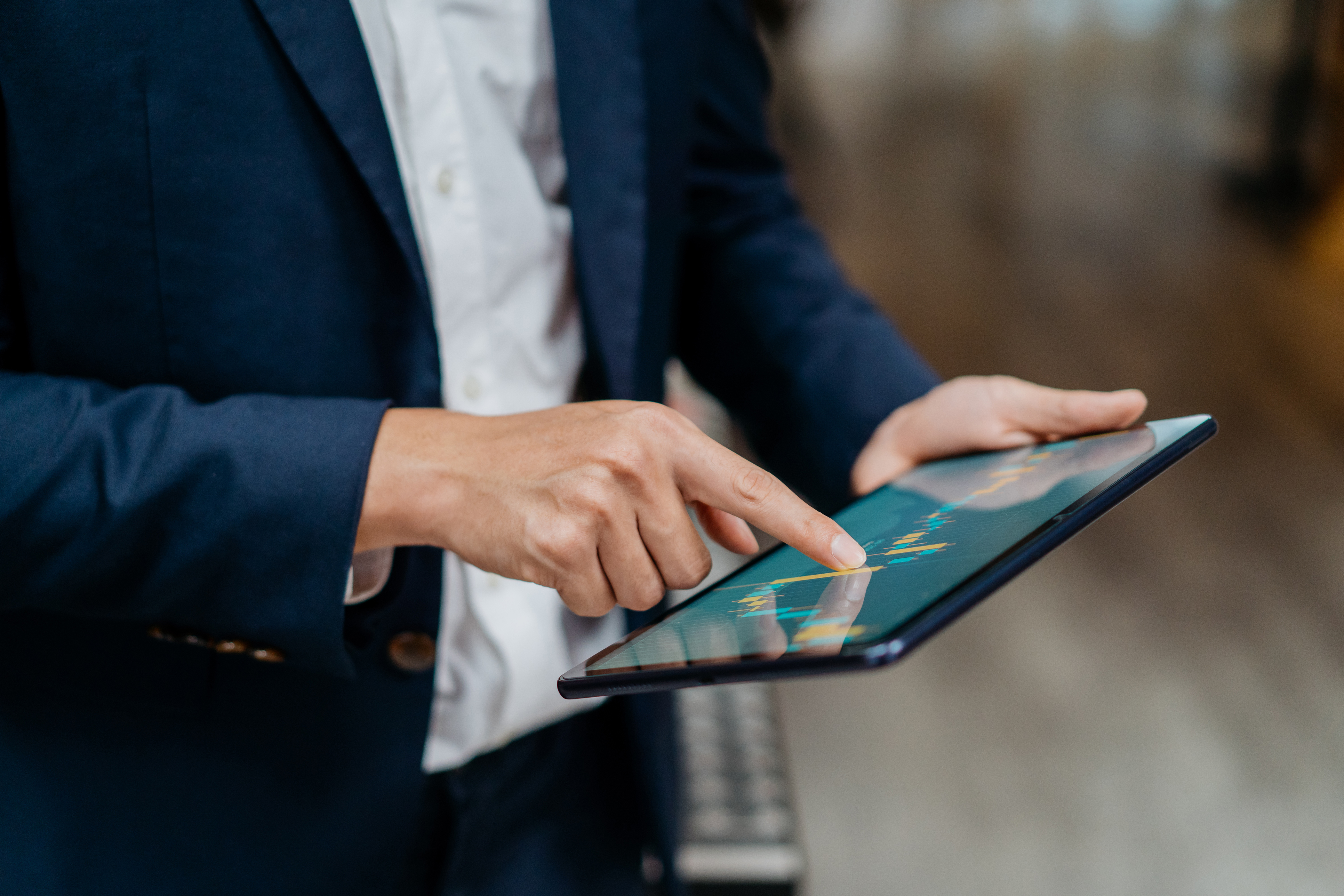 Image of an Asian businessman checking stock market chart on digital tablet.
