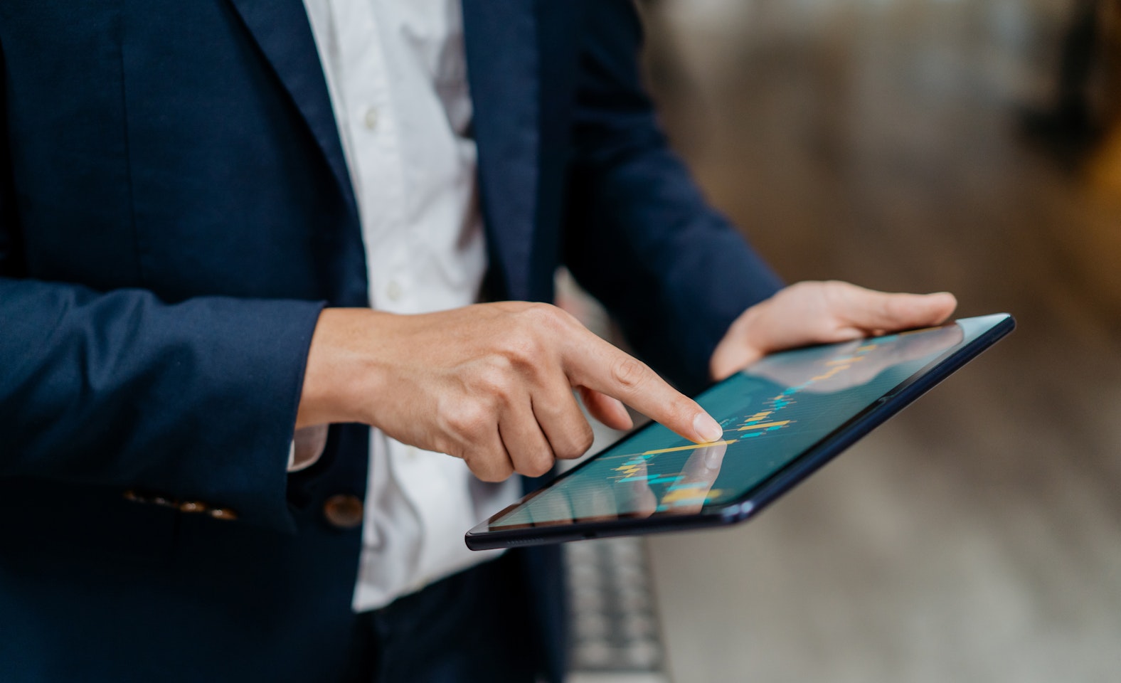 Image of an Asian businessman checking stock market chart on digital tablet.